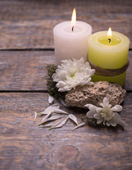 Two aromatic candles with flowers on a wooden background with copy space.