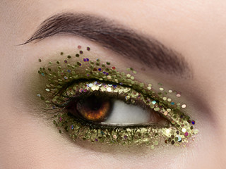 Beautiful macro shot of female eye with ceremonial makeup. Perfect shape of eyebrows, eyeliner and...