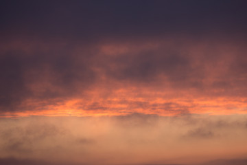 Fototapeta na wymiar clouds at dawn. Fiery red rising sun behind the clouds. headpiece