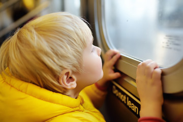 Little boy looks out the window of the car in the subway in new York.