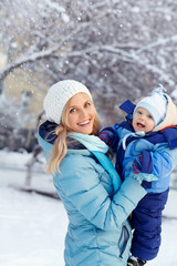 Fototapeta premium happy mother and baby in winter park. family outdoors