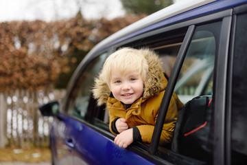 Cute little boy ready for a roadtrip or travel. Family car travel with kids.