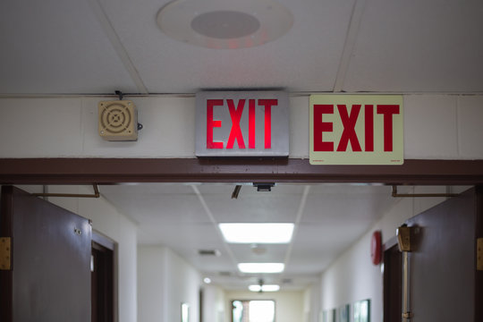 red emergency exit sign in the dark room. illuminated office exit sign.