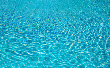 Naklejka na ściany i meble Background of rippled pattern of clean water in a blue swimming pool.