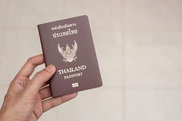Hand holding Thailand passpor