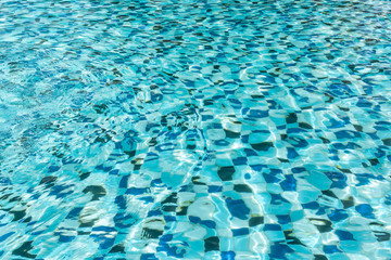 Background of rippled pattern of clean water in a blue swimming pool.