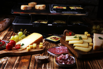 Delicious traditional Swiss melted raclette cheese served in individual skillets with salami.