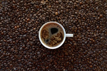 white cup against a background of coffee beans