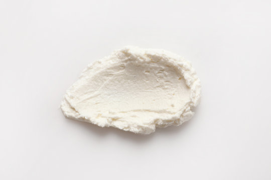 Fototapeta Smear of tasty cream cheese on white background, top view