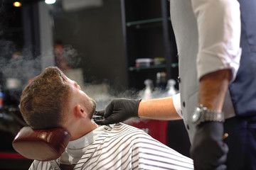 View from back of man on facial procedure in barber shop 