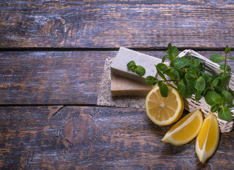 Natural cosmetic soap from organic ingredients with lemon slices on a wooden background with copy space.