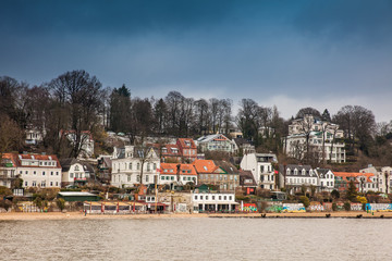 Fototapeta na wymiar Beautiful houses and beaches on the banks of Elbe river in Hamburg on a cold end of winter day