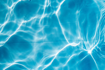 Fototapeta na wymiar Background of rippled pattern of clean water in a blue swimming pool