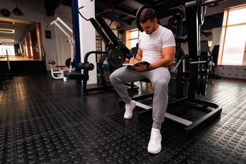 Fitness trainer writes workout plan close up in gym