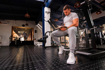 Fototapeta na wymiar Fitness trainer writes workout plan close up in gym