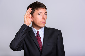 Studio shot of thoughtful businessman listening and thinking