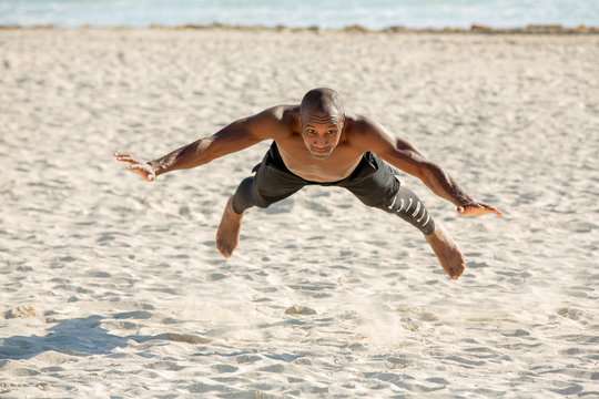 Man doing explosive push up on the beach