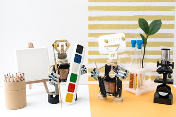 Metal robot with a brush in his hand. Stem plus art is equal to STEAM. Science, technology,...