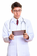 Studio shot of man doctor using digital tablet