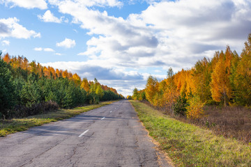 the road with broken asphalt in Chuvashia in Russia, shot on a clear autumn day