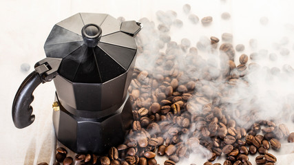 Italian coffe pot filled with coffee beans on white wooden background. Copy space.