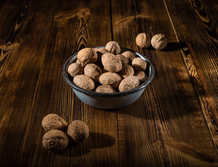 Walnuts in an old bowl on a wooden surface in rustic style