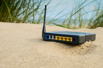 router on the sand on a summer day, the concept of modern technology, remote work, a network for...