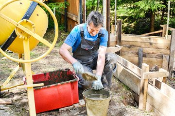 Production of cement mortar in a concrete mixer. The construction of the formwork for a fence.