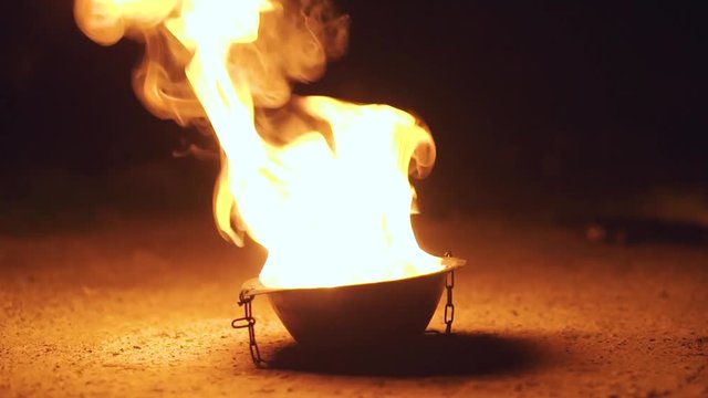 Burning fire in the metal fire bowl with chains