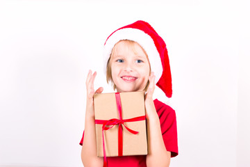 Happy boy in Santa red hat holding Christmas gift in hand. Christmas concept.