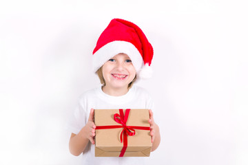 Happy boy in Santa red hat holding Christmas gift in hand. Christmas concept.