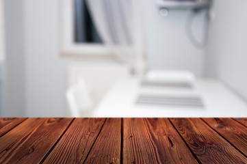 Blurred kitchen interior with wooden table on the front