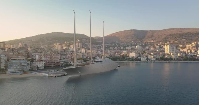 Aerial drone view of luxury yacht (Yacht A) parked in Saranda port in summer 2018.  Sarande, Albania at sunset - 4k