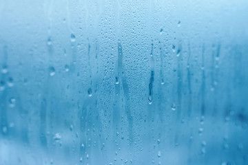 The texture of natural water drops on glass. High humidity indoor. Close-up with condensation - obrazy, fototapety, plakaty