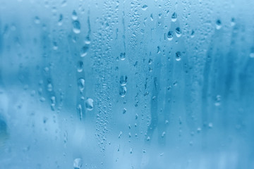The texture of natural water drops on glass. High humidity indoor. Close-up with condensation