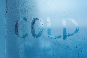 Inscription cold on glass close-up with condensation. Background with water drops. High humidity...