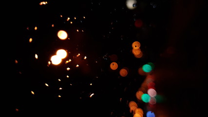 Fototapeta na wymiar Rain drops on window with road light bokeh, City life in night in rainy season abstract background,water drop on the glass, night storm raining car driving concept.