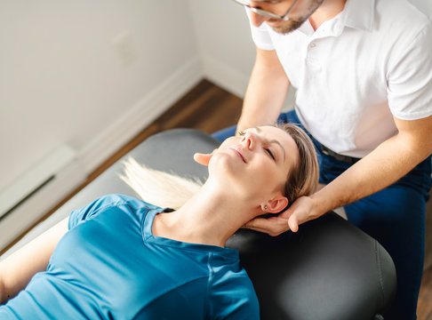 A Modern rehabilitation physiotherapy man at work with woman client working on neck