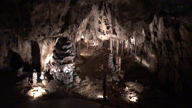 Sloup-Sosuvka Caves in Moravian kras, Czech Republic. Stalactites and stalagmites of Sloupsko-sosuvske cavern in South Moravia. Limestone underground. Unrecognizable people on walking tour in dark