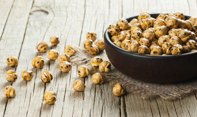 turkish leblebi, famous nut, stack of yellow roasted chickpea in brown bowl on wooden rustic...