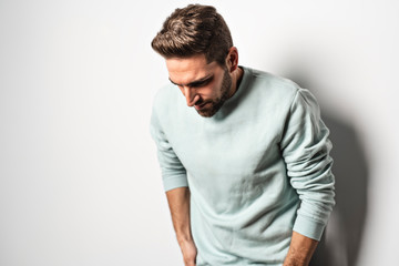Fototapeta premium A young man looking away while standing on gray background