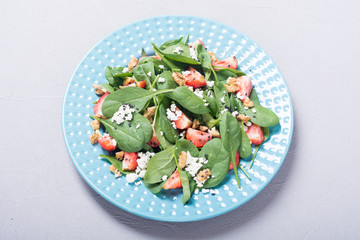Strawberry salad with spinach , cheese and walnut . Healthy food