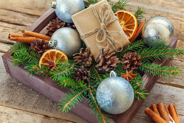Christmas New Year composition winter objects gift box fir branch pine cones cinnamon sticks on old shabby rustic wooden background. Xmas holiday december decoration. Flat lay top view copy space