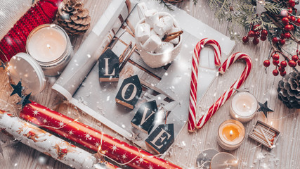 Christmas decor: Warm sweater, cup of hot cocoa with marshmallow, candy, candles and Christmas tree. Winter mood, decoration.