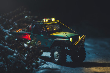 radio-controlled car in the snow at night, lights shine. Christmas present rc car