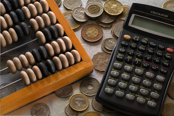 Calculator, old abacus and a bunch of coins