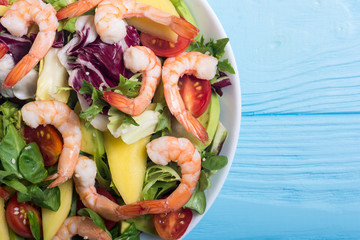 Mix of salad with shrimps , avocado and cherry tomatoes . Healthy food background
