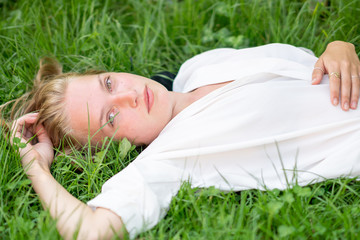 Naklejka na ściany i meble Young woman relaxing on the grass