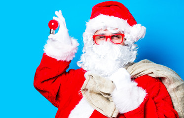 Fototapeta na wymiar Funny Santa Claus have a fun with light bulb on blue background
