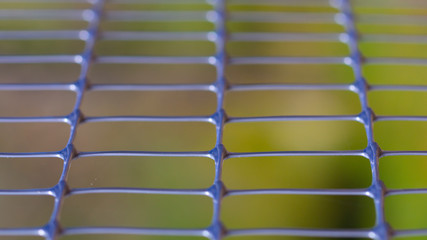 Fototapeta premium Green old metal mesh with selective focus. Close-up, abstract image